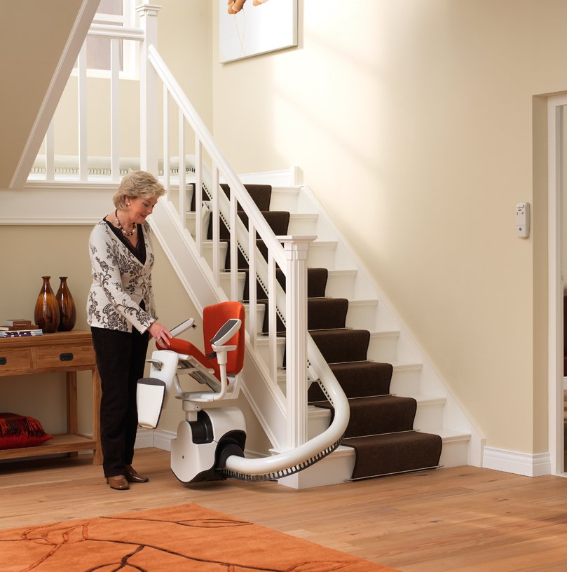 Picture of a lady folding the seat up on her curved stairlift