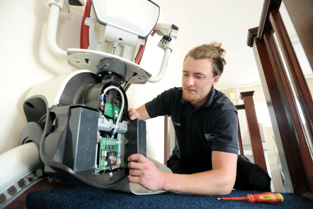 Picture of an engineer installing a stairlift