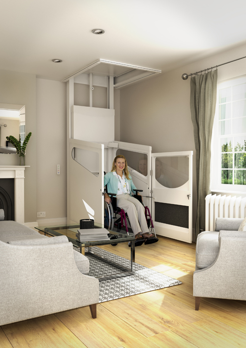 A woman in a wheelchair uses a house lift in a modern living room with neutral furnishings and natural light, highlighting accessibility for disabled users.