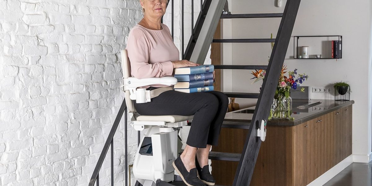 Picture of Lady carrying books upstairs on her Handicare 1100
