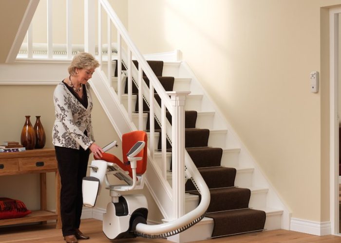 Picture of a lady folding the seat up on her curved stairlift